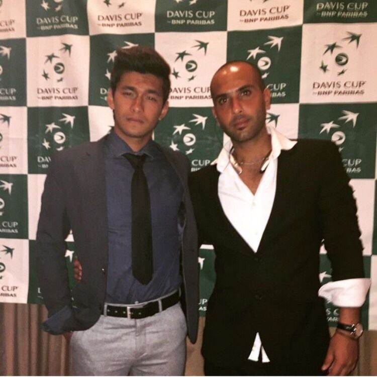 Naser in a suit in front of the Davis Cup backdrop