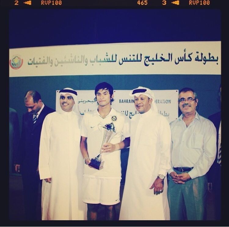 A young Naser holding the GCC Cup trophy with officials